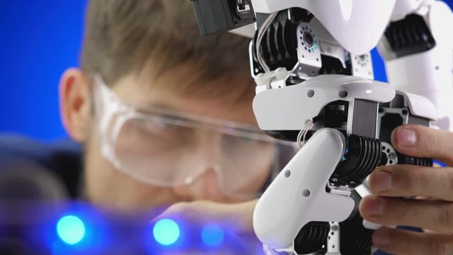 Close up electronics engineer working in lab building and testing robot mechanism.
