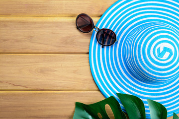 top view blue hat and sunglasses on a wooden table