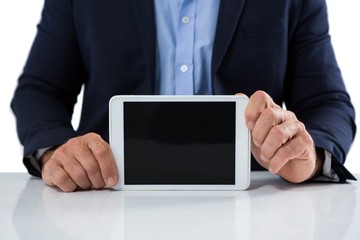 Businessman showing digital tablet against white background