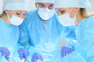 Group of surgeons at work while operating at hospital. Health care and veterinary concept