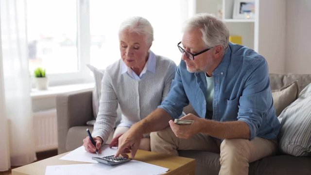 senior couple with money and bills at home