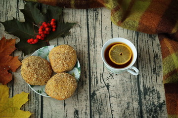 Tea with lemon, autumn leaves and cookies