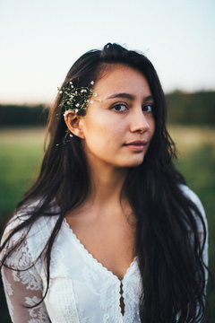 Delicate portrait of a young woman with a flower in her hair