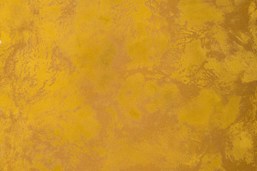 background of the plastered texture with marble effect gold color. artistic background handmade