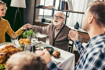 Family praying before holiday dinner