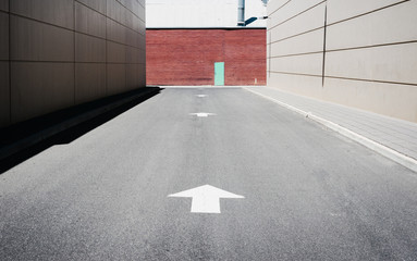 arrows on road leading to a blue door