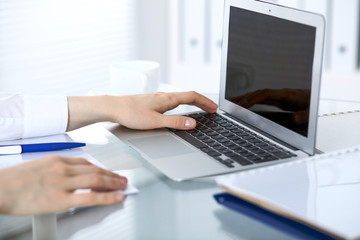 Close up of business woman hands typing on laptop computer