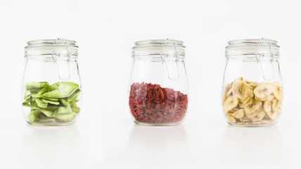 ISOLATED COLLECTION RUSTIC BUCKLED GLASS WITH DRIED FRUIT ON WHITE BACKGROUND. DECORATION STILL LIFE.