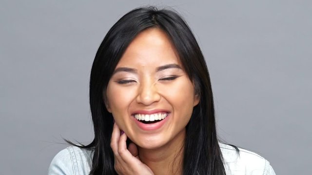 Young amazing asian pretty woman looking camera isolated and laughing