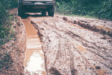 Wheel closeup in a countryside landscape with a muddy road
