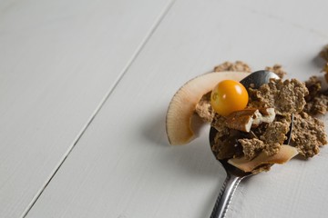 Wheat flakes and fruit in spoon
