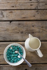 Bowl of froot loops and marshmallow with milk jug