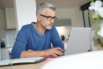 Middle-aged man working from home-office on laptop