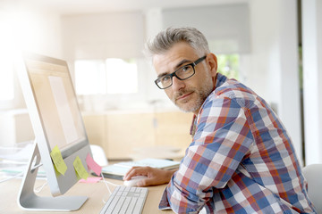 Web designer working in office on desktop computer