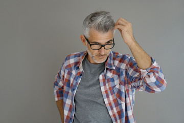 Casual man with grey hair standing on background, isolated