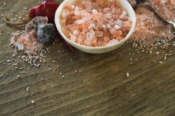Fototapeta na wymiar Himalayan salt with spices on wooden table