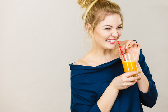Happy woman holding fresh orange juice
