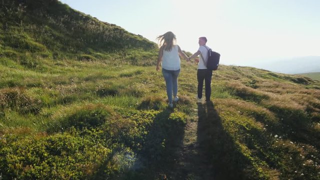 Back view. Couple walking on the mountain range.