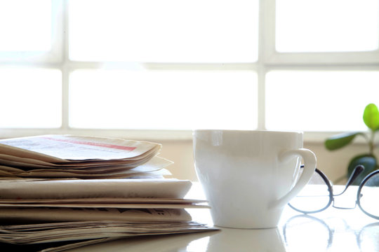 Newspaper with coffee on table
