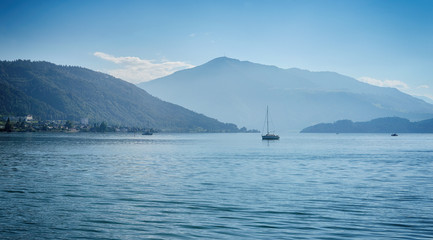 Fototapeta na wymiar Swiss lake zug with boats and ferry and blue sky