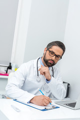 doctor writing in clipboard