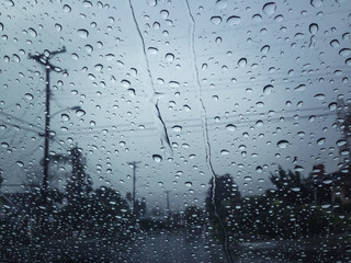 Rainy windshield with blurry background captured with mobile phone.