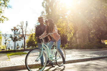 Boyfriend helping girlfriend riding bike