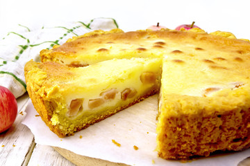 Pie apple with sour cream on parchment and board