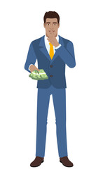 Businessman with money making hush sign