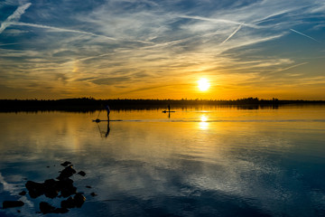 Naklejka premium Stand up paddle silhouette and a beautiful sunset