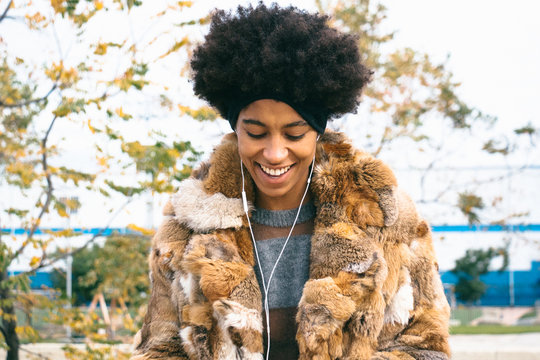 Afro woman listening music with earphones