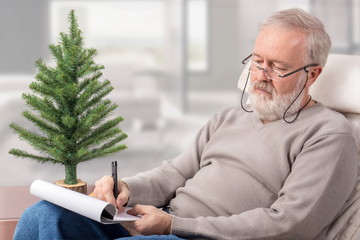 Grandfather making the shopping list for winter holidays