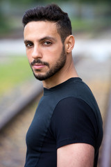 Fototapeta premium young man standing outside next to train tracks