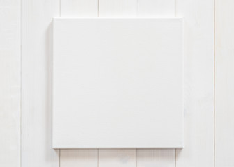 White canvas frame mock up template square size on white wood wall for arts painting and photo hanging interior decoration - obrazy, fototapety, plakaty