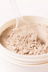 Cosmetic clay powder in the plastic container