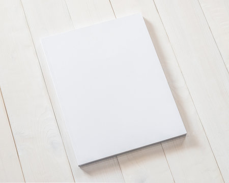 Blank A4 size book cover mockup template with page front side paperback on white surface on wood table
