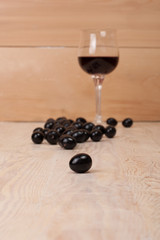 Glass of red wine and grapes on rustic wood table