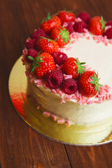 Christmas cake with berries on wooden background