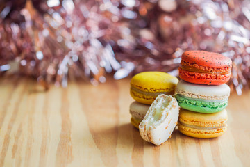 Homemade delicious colorful French macaron or Italian macaron stack on wood table copy space with bokeh background. Macarons is French dessert for served with afternoon tea or coffee break.