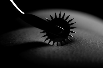 BDSM nude submissive woman act with Wartenberg wheel - obrazy, fototapety, plakaty