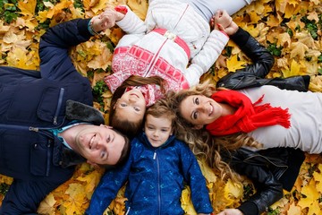 A happy family having fun in the park in autumn. Family, love, happiness concept. Family of four