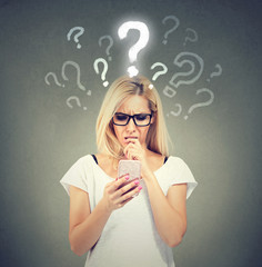 Misunderstanding and distant call. Upset confused woman talking or texting on mobile phone has many...