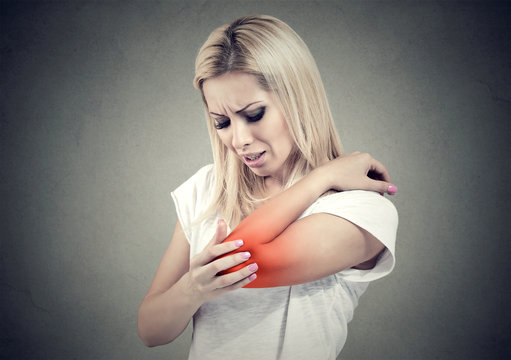 Sad woman with joint inflammation. Female's elbow. Arm pain and injury.