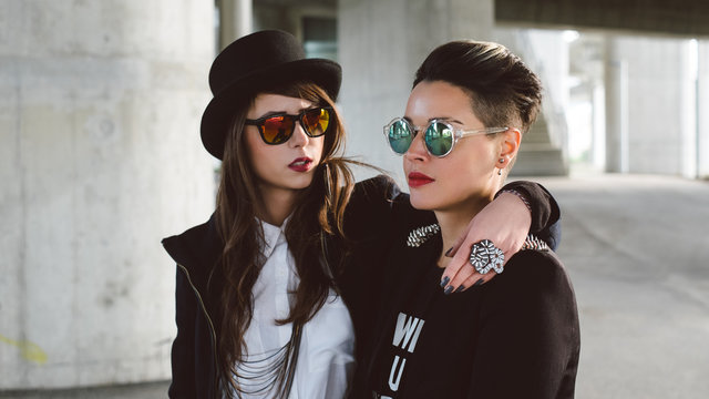 Two stylish women with sunglasses standing on the street