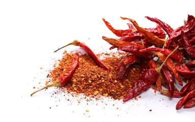 Dry red hot chili peppers with flakes, pile isolated on white background
