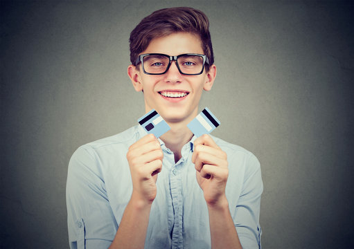 Happy debt free student holding a credit card cut in two pieces