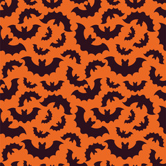Silhouettes of bats on orange background. Seamless pattern . Halloween background