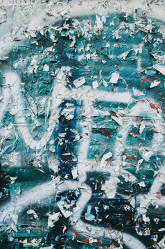staples and remnants of posters on a painted wall