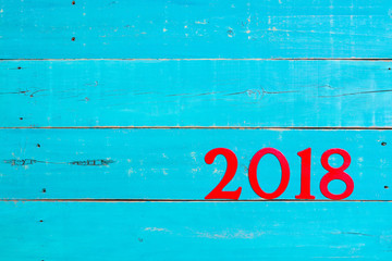 Year 2018 in bold red hanging on antique rustic teal blue background; Happy New Year holiday concept