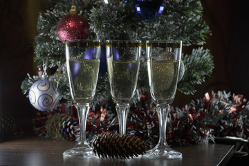 Crystal glass with white wine under the Christmas tree,